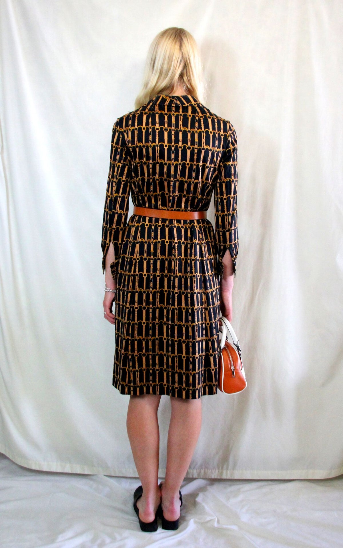 Rent 1970s Vintage dogtooth black, gold and brown chain print shirt dress with button front
