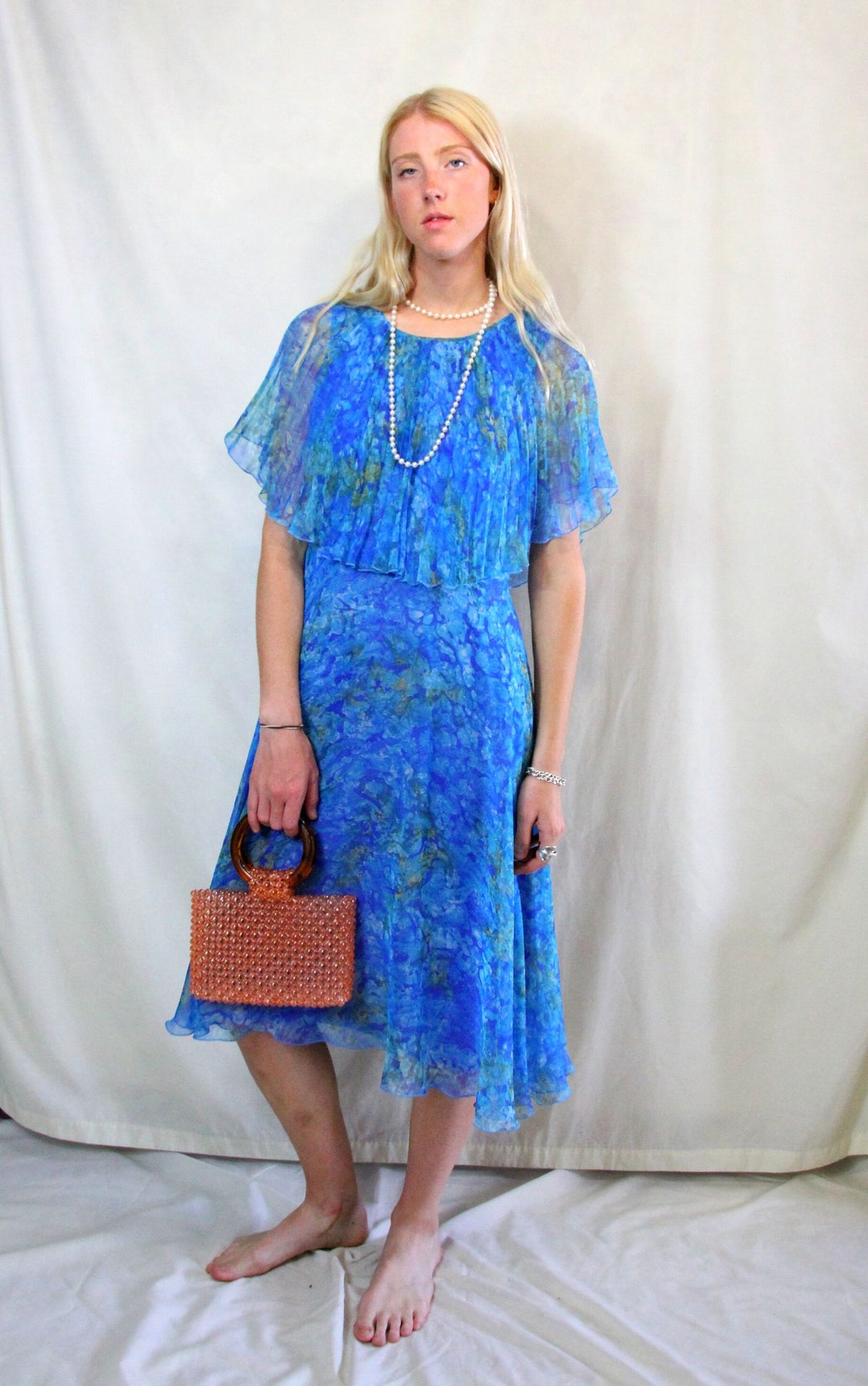 Rent Vintage 1940's style turquoise blue printed dress with front flapper and cape style neck and sleeves. Zips at back