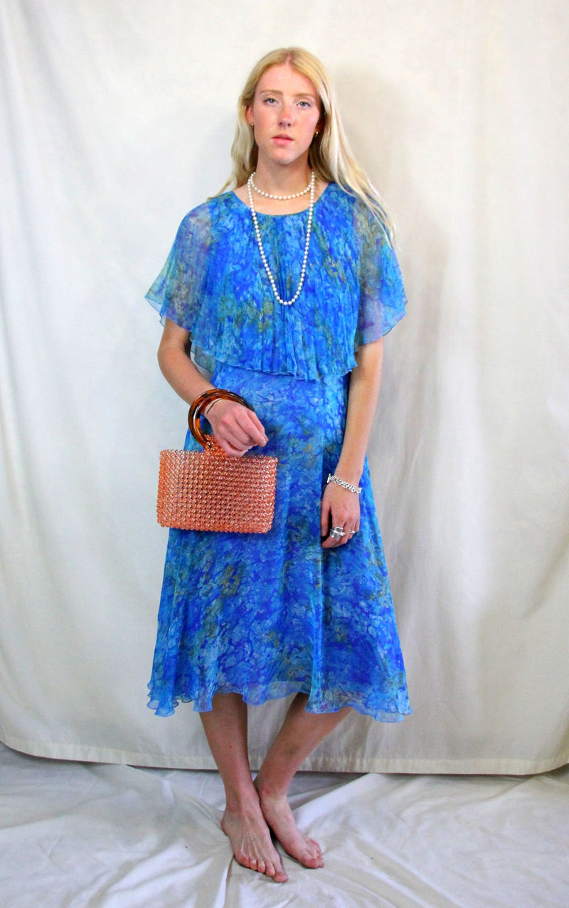 Rent Vintage 1940's style turquoise blue printed dress with front flapper and cape style neck and sleeves. Zips at back