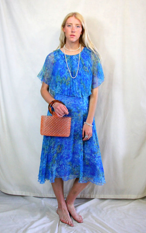 Rent Vintage 1940's style turquoise blue printed dress with front flapper and cape style neck and sleeves. Zips at back 